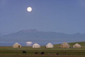 Moon rising over Song Kol lake and nomads Yurts