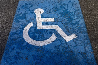 Sign for parking for people with disabilities on torn tar