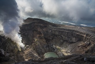 Steaming fumarole with crater lake on the Gorely volcano