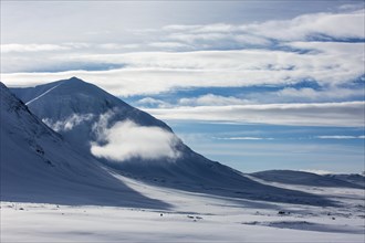 Cloud between mountains in the snow
