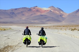 Two cyclists with luggage ride on the runway of the lagoon route