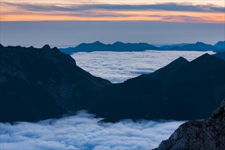 Mountain peak with sea of fog on the blue hour