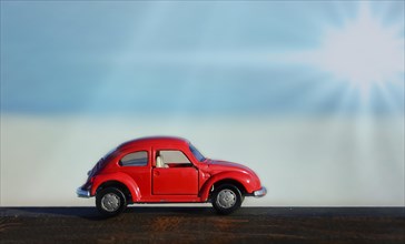 Red toy car with sunbeams