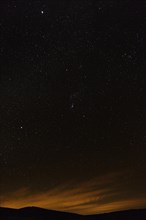 Starry night sky over a mountainous landscape near La Pobla de Segur