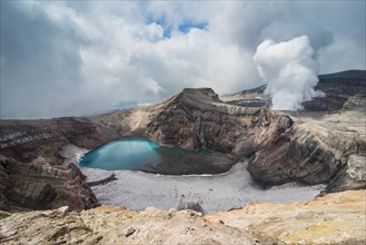 Steaming fumarole with crater lake on the Gorely volcano