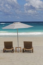 Two beach chairs with parasol on the beach