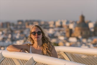Young woman in sunglasses looks into the camera