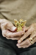 Hands of an old woman holding a Christmas angel