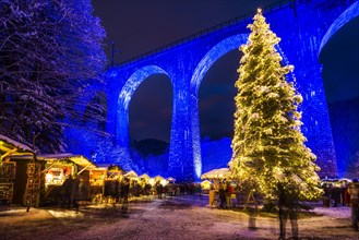 Snowy Christmas market under a railway viaduct