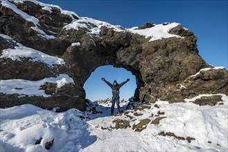 Man standing in front of a rocky arch