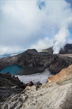 Steaming fumarole with crater lake on the Gorely volcano