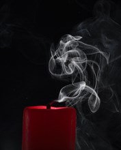 Smoky candle in front of a black background