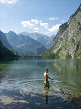 Young man bathes in lake Obersee