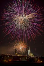 Fireworks over Schwaz on New Year's Eve with hospital church and parish church