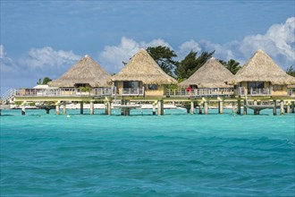 Overwater bungalows on stilts in luxury hotel
