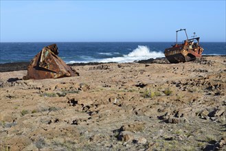 Rusty wreck of a fish trawler on the rocky shore