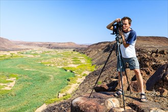 Photographer with a camera at the Huab River, Damaraland