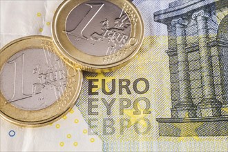 Two one Euro coins on top of five Euros paper currency bank note