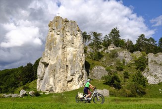 Cyclist in front of climbing rock Burgstein