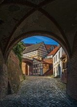 Gate of the city wall with a view of timbered houses