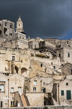 Houses with cathedral Maria Santissima della Bruna with dark cloudy sky