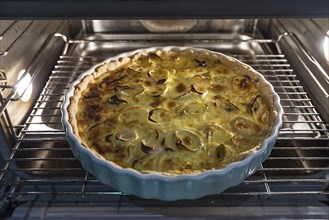 Baked leek quiche in round form in the oven