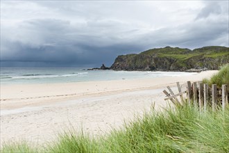 Sandy beach with dark clouds over the coast