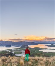 Hiker overlooking Lake Wanaka and mountains