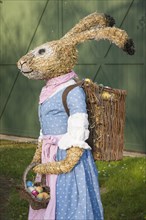 Easter bunny as straw doll with egg basket