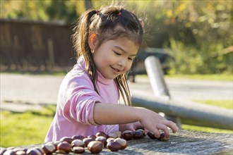 Eurasian girl sitting at wooden table