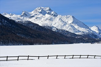 Summit Piz de la Margna above the frozen Lake Silvaplana