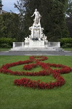 Red flowers arranged as violin key with Mozart monument