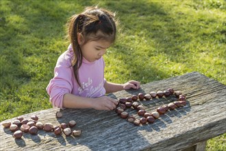 Eurasian girl sitting at wooden table