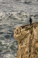Cliff fisher at steep coast