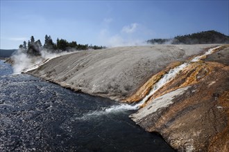 Outlet of the Excelsior Geyser in the Firehole River with mineral deposits