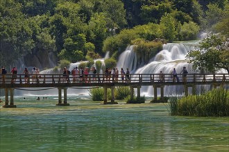 Tourists bathe at the waterfall Smotorcycleinski Buk
