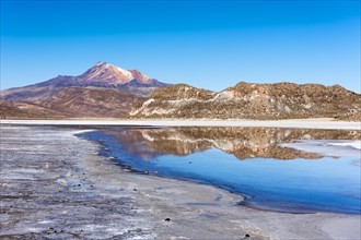 Volcano Cerro Tunupa with reflection in the Salar de Uyuni