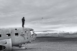 Man on aircraft wreck Douglas DC-3 controls Drone