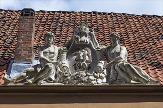 Art Nouveau figures on a roof with initials of the builder