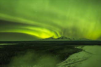 Aurora over the fog shrouded Copper River and mounts Sanford Drum and Wrangell