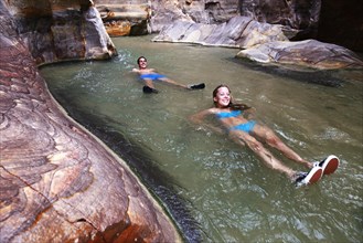 Young couple floats at the canyon of Wadi Mujib