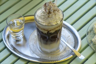 Iced coffee with cream on a silver tray