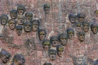 Close-up of faces from communist era on facade of city market