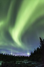 Northern Lights or Aurora Borealis above river Gamajahka or Kamajakka