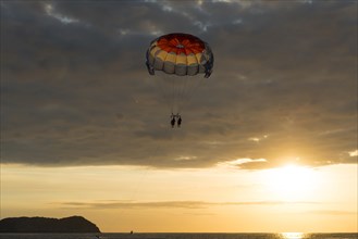 Parasailing at sunset over the sea