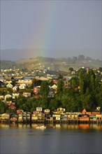 Rainbow over the city with stilt houses