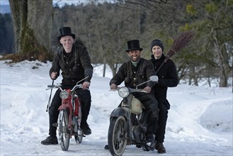 Chimney sweepers in winter on old mopeds
