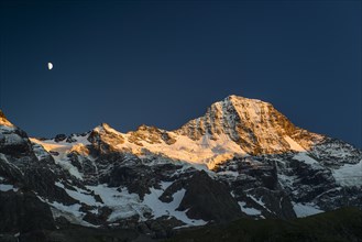 Snow-capped Breithorn with moon at sunset