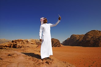 Bedouin uses his smartphone at Rock Arch