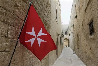 Maltese flag in narrow alleyway in historic centre